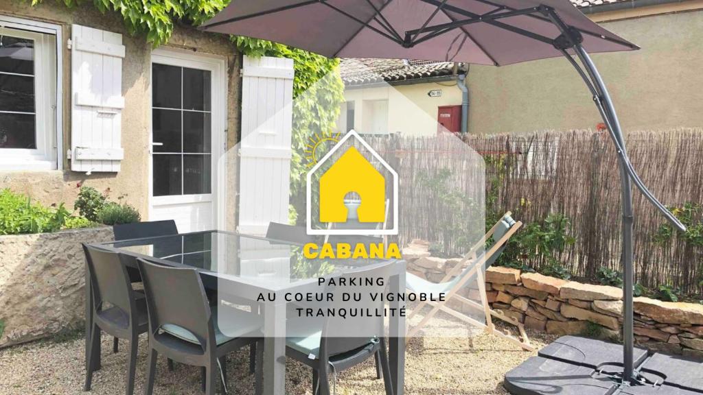 una mesa y sillas con sombrilla frente a una casa en CABANA & Maison à Solutré-Pouilly - Cœur de village, en Bussières