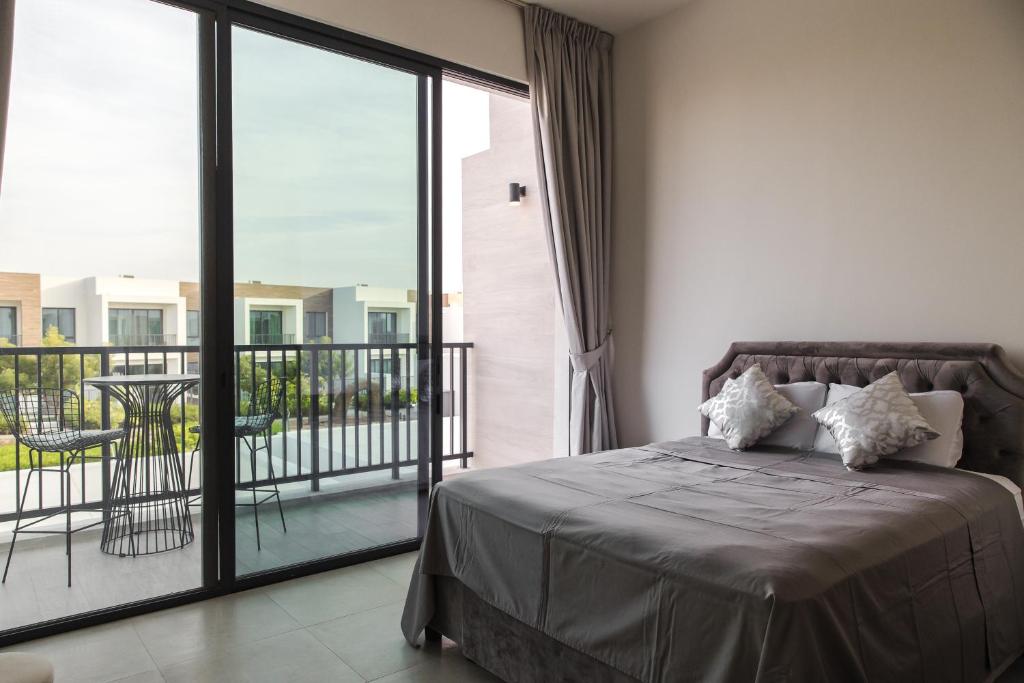 een slaapkamer met een bed en een balkon bij Luxury feel in Ras al Khaimah