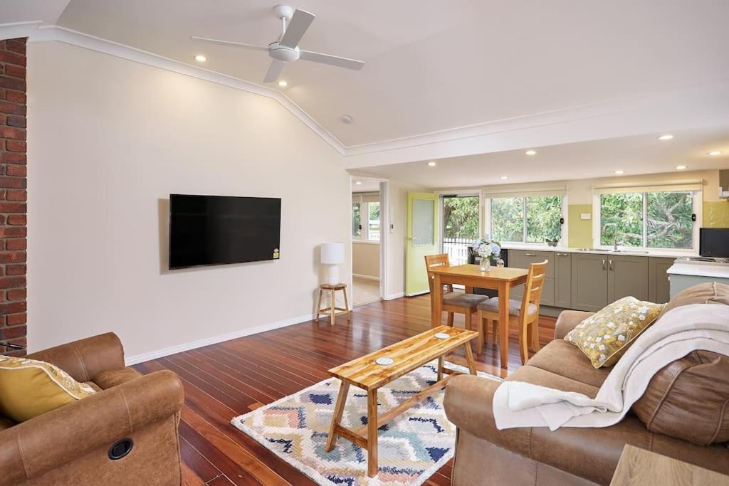 a living room with a couch and a table at Moonya Avocado Farm Cottage - with early check-in in Mount Tamborine