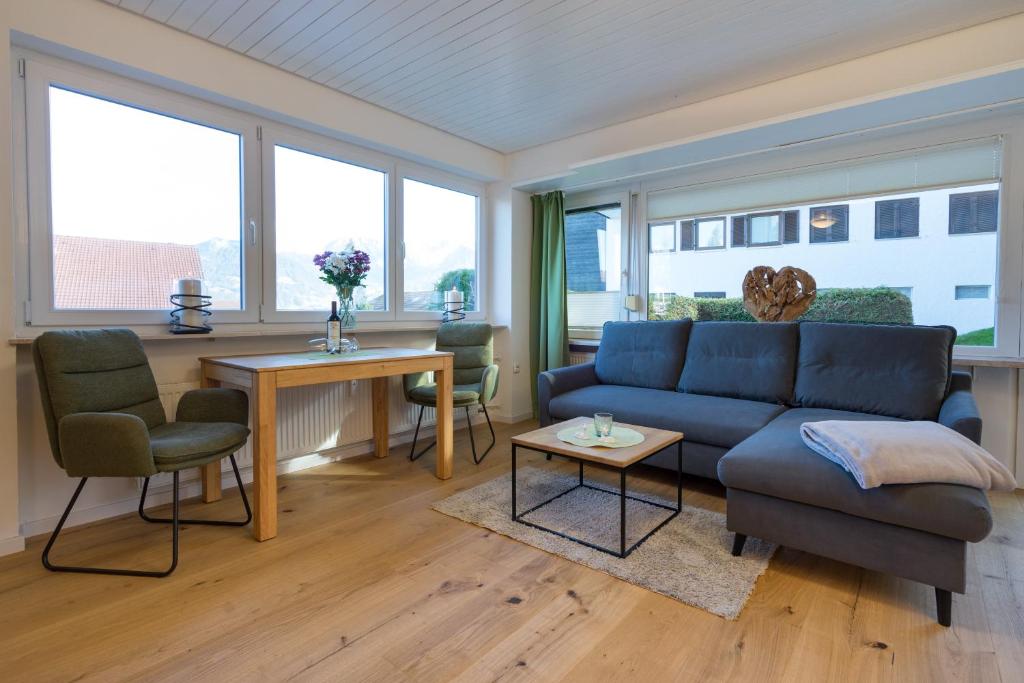 a living room with a blue couch and a table at Berglust in Obermaiselstein