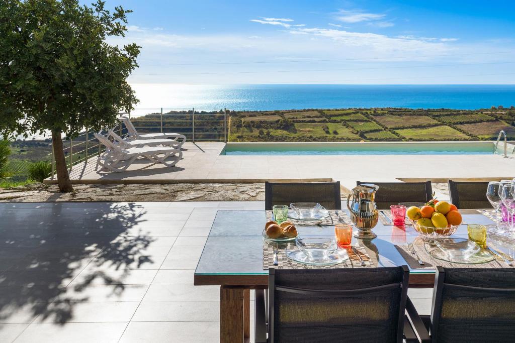 una mesa con un bol de fruta en la parte superior de un patio en Giglio di Mare en Siculiana