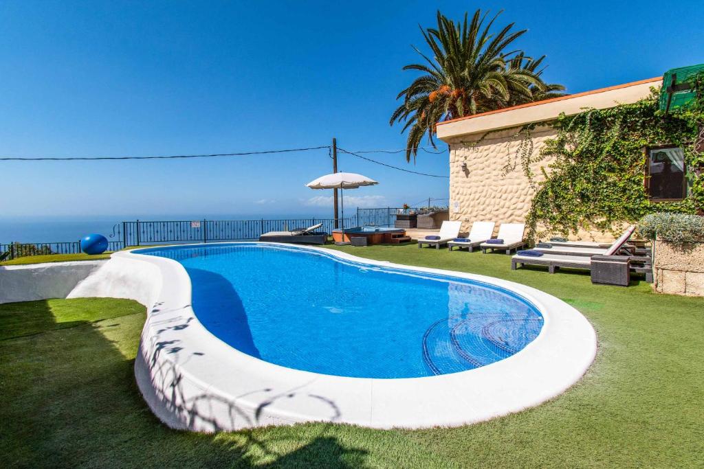 a swimming pool in a yard next to a house at Villa Isabel Sol in Adeje