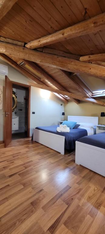 1 dormitorio con 2 camas y techo de madera en XX Miglia rooms & apartments, en Catania