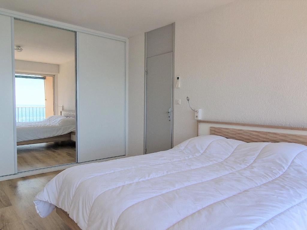 a bedroom with a large white bed and a mirror at Appartement Banyuls-sur-Mer, 3 pièces, 4 personnes - FR-1-309-281 in Banyuls-sur-Mer