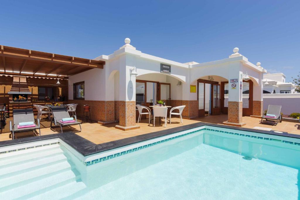 a villa with a swimming pool and a patio at Villa Palina in Puerto del Carmen