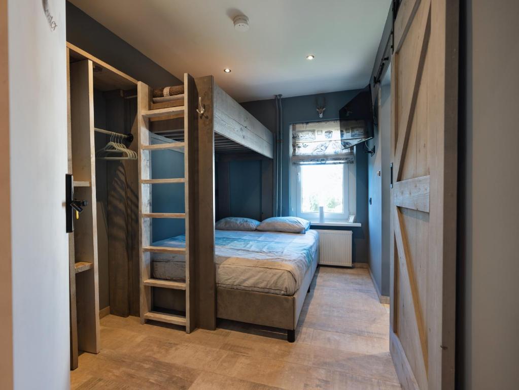 een kleine slaapkamer met een stapelbed en een raam bij Familiekamer B&B Gezond Aan Zee, 3 persoons, meerprijs voor wellness in Ouddorp