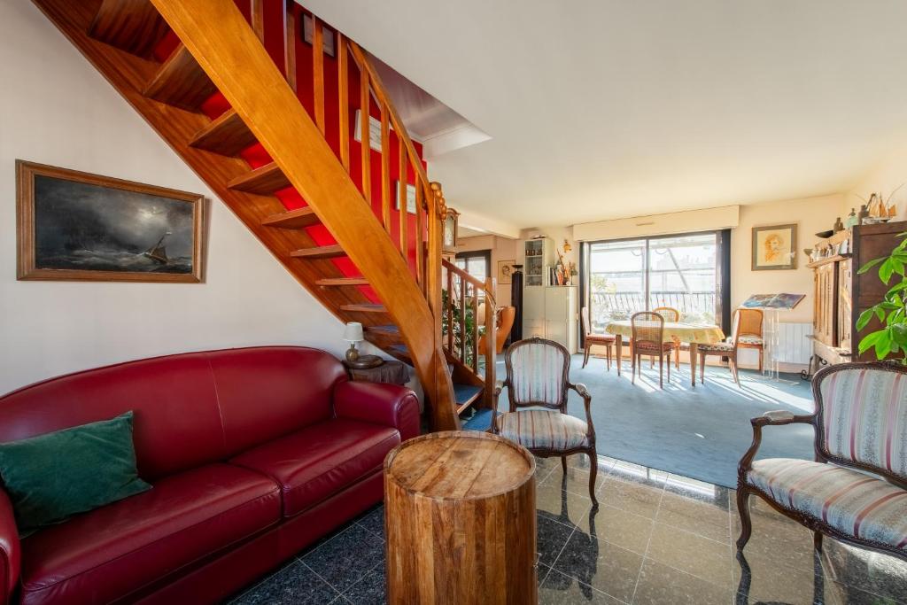 a living room with a red couch and chairs at 120 Grenelle - Spacieux Duplex avec vue sur la tour Eiffel in Paris