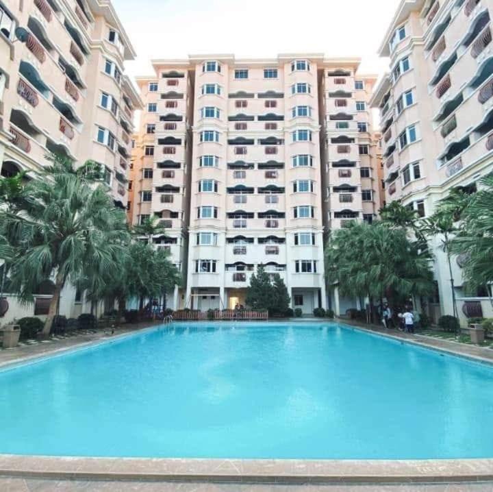 a large swimming pool in front of a large building at ARAH Homestay @ Kuhara Court Tawau in Tawau