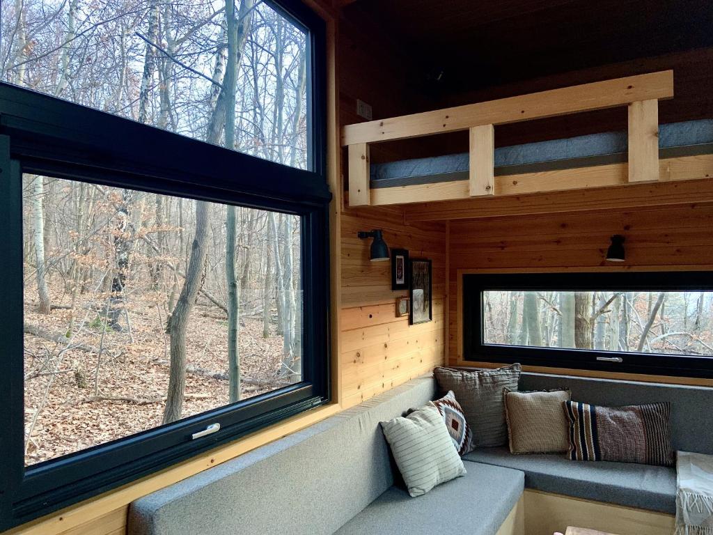 sala de estar con 2 ventanas y sofá en POP Tiny House Mátra, en Mátraszentimre