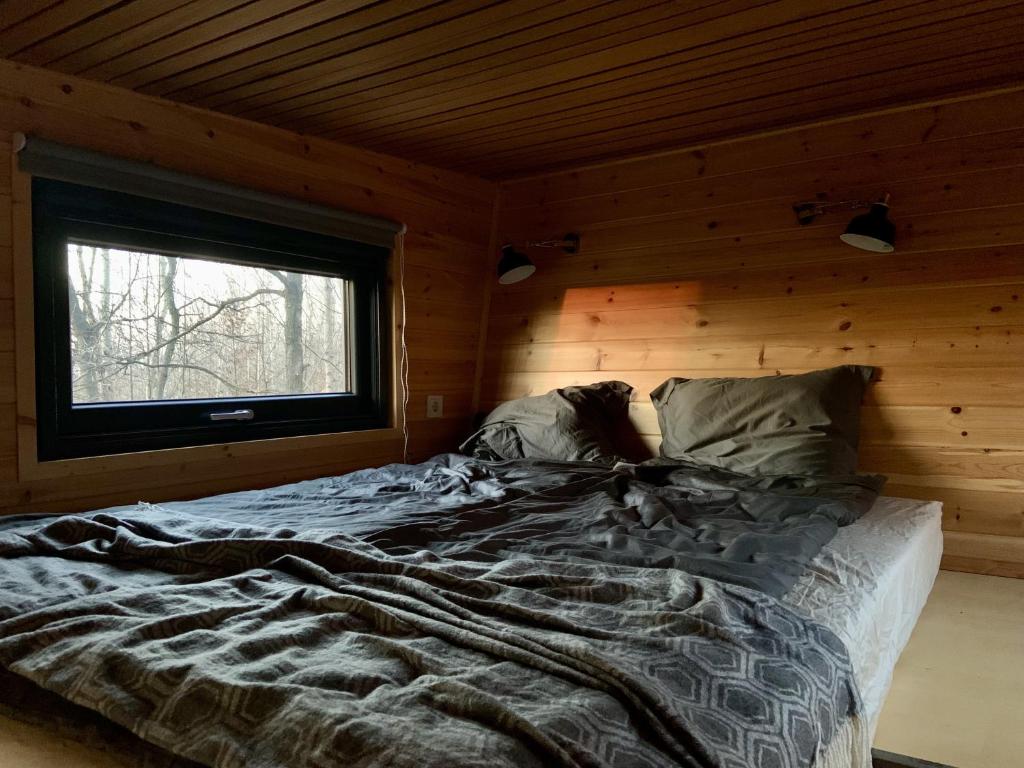 a large bed in a room with a window at POP Tiny House Mátra in Mátraszentimre