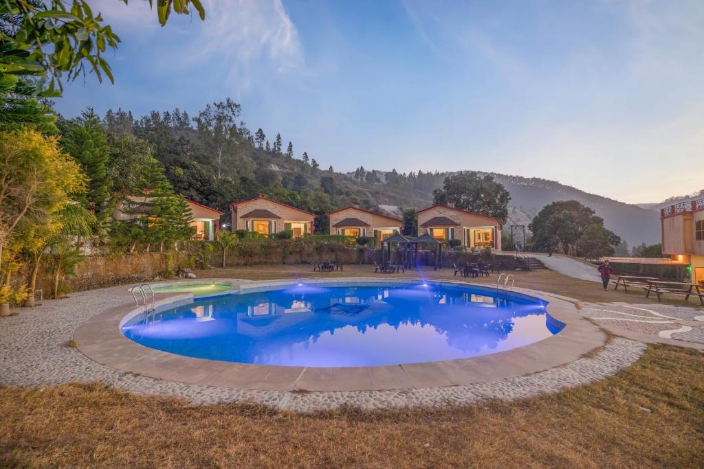una gran piscina en un patio con casas en LaTigre Resort, en Tota Ām