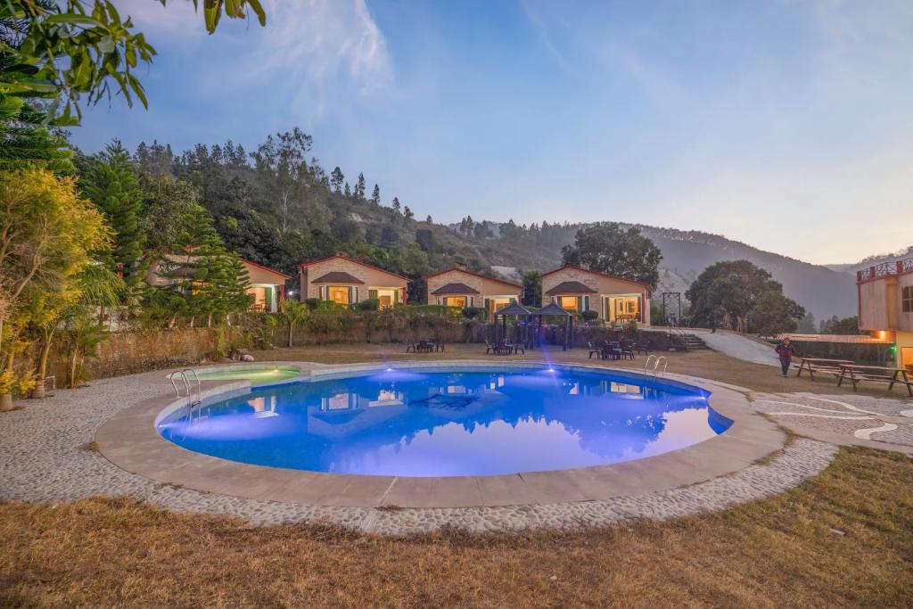 a large swimming pool in a yard with houses at LaTigre Resort in Tota Ām