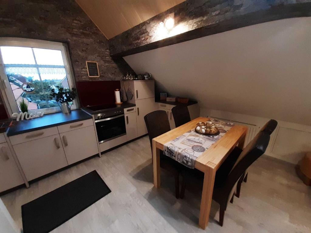 une cuisine avec une table en bois et une salle à manger dans l'établissement Ferienwohnung Zum Lotsen, 45227, à Jemgum