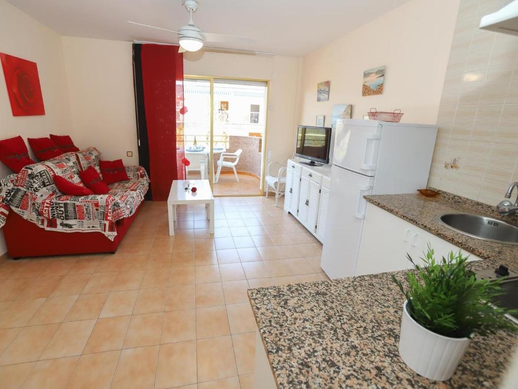 eine Küche und ein Wohnzimmer mit einem Sofa und einem Tisch in der Unterkunft Clara-154 in Salou