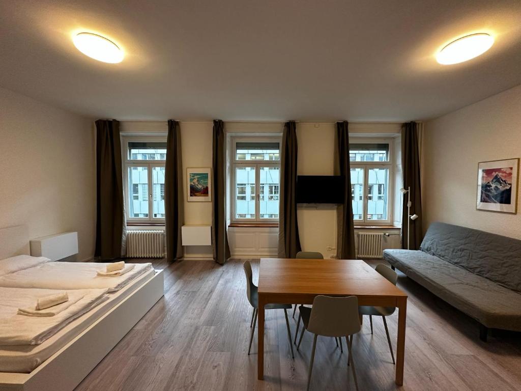 Cette chambre comprend un lit, une table et un canapé. dans l'établissement HITrental Seefeld - Kreuzstrasse Apartments, à Zurich