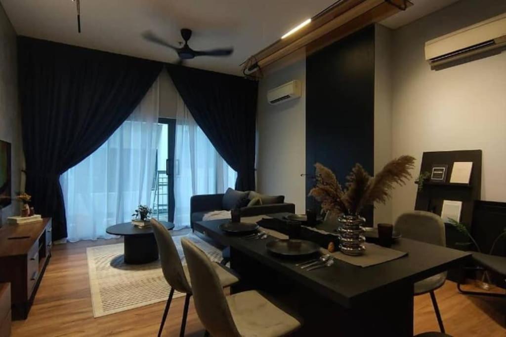 uma sala de estar com um sofá e uma mesa com cadeiras em Premium Darkdesign 6pax In Desa ParkCity WifiTvbox em Kuala Lumpur