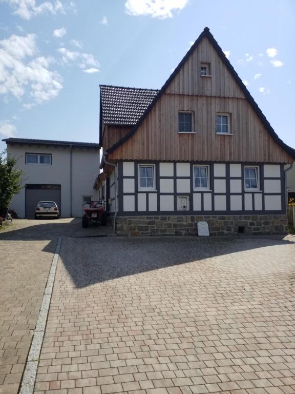 a large wooden building with a car parked in front of it at Ferienwohnung Füssel NICHT FÜR MONTEURE in Bad Staffelstein