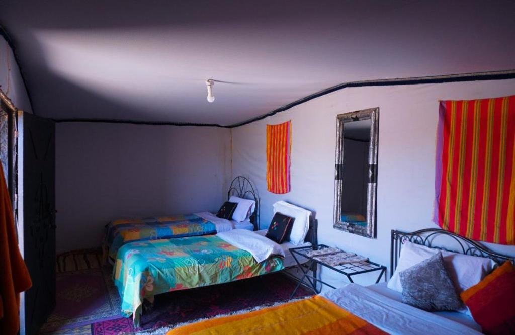 1 dormitorio con 2 camas y sofá en Erg Chegaga Lodge en Mhamid