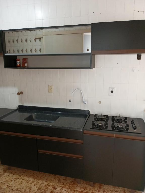 a kitchen with a sink and a stove in it at Quarto próximo ao shopping Moinhos in Porto Alegre