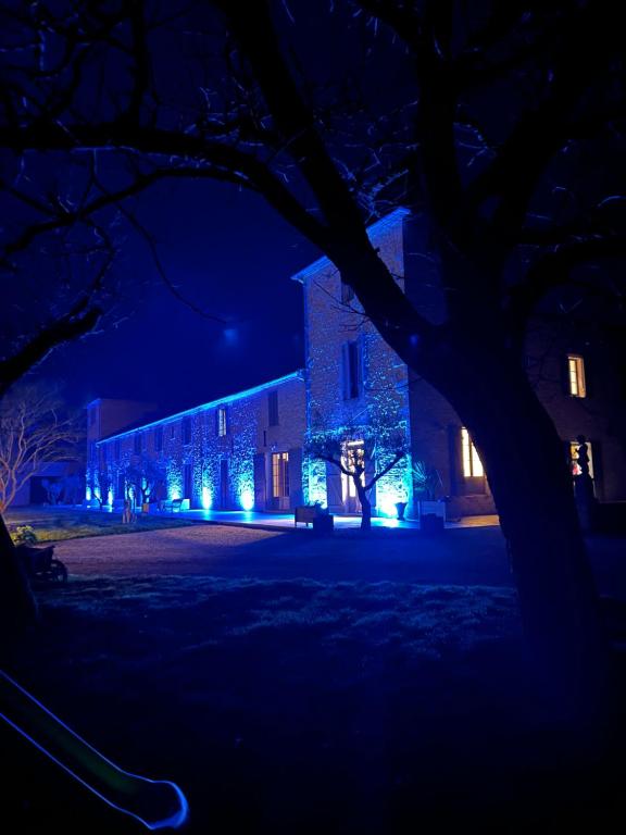 un bâtiment est éclairé la nuit avec des lumières bleues dans l'établissement Gites du Fort au Prince, à Eymet
