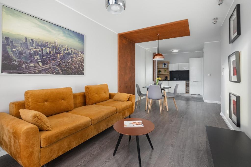 een woonkamer met een bank en een tafel bij Raginisa Modern Apartments in Szczecin
