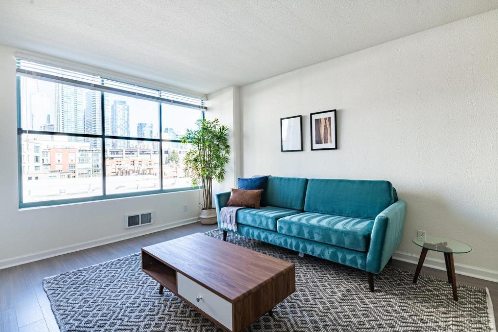 ein Wohnzimmer mit einem blauen Sofa und einem Tisch in der Unterkunft S Beach 1br w rooftop tennis nr muni lightrail SFO-1660 in San Francisco