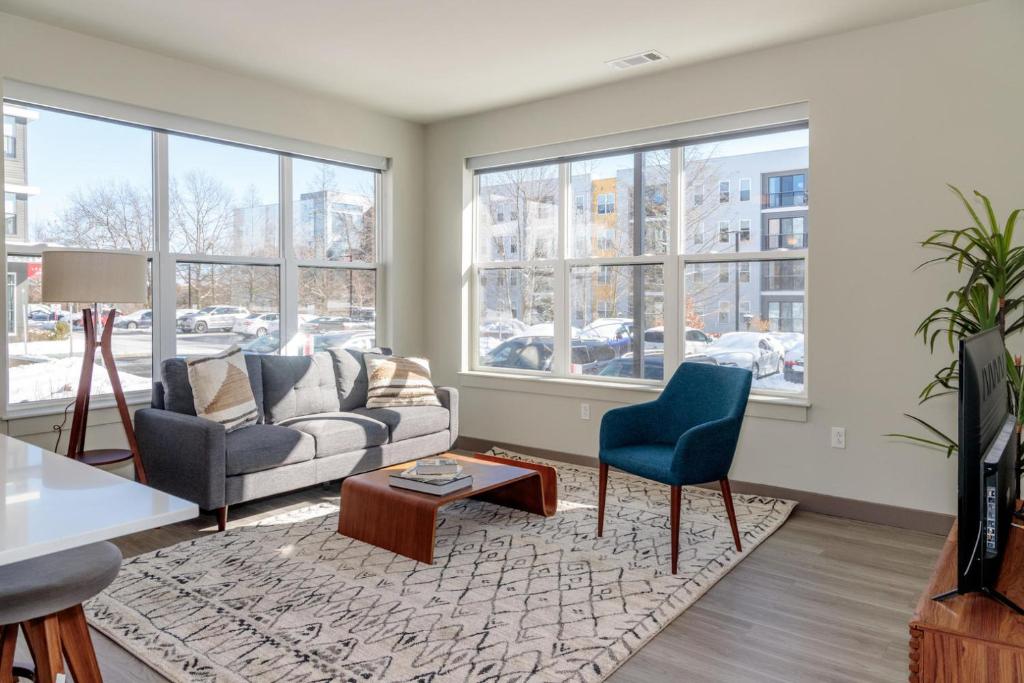 a living room with a couch and chairs and windows at Burlington 2br w gym wd nr dining shops BOS-977 in Burlington