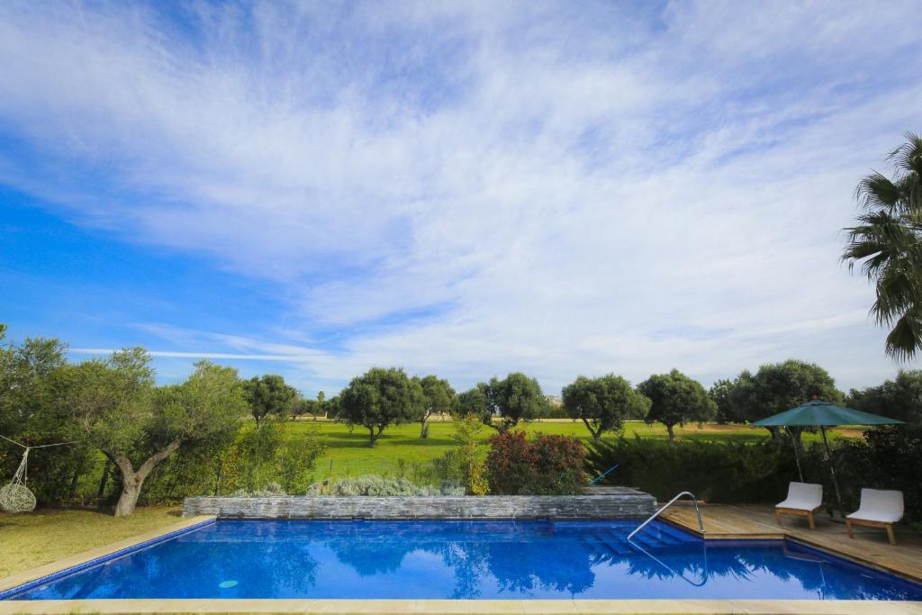 una piscina con 2 sillas y una sombrilla en New Aiguesverdes ONLY FAMILIES en Reus