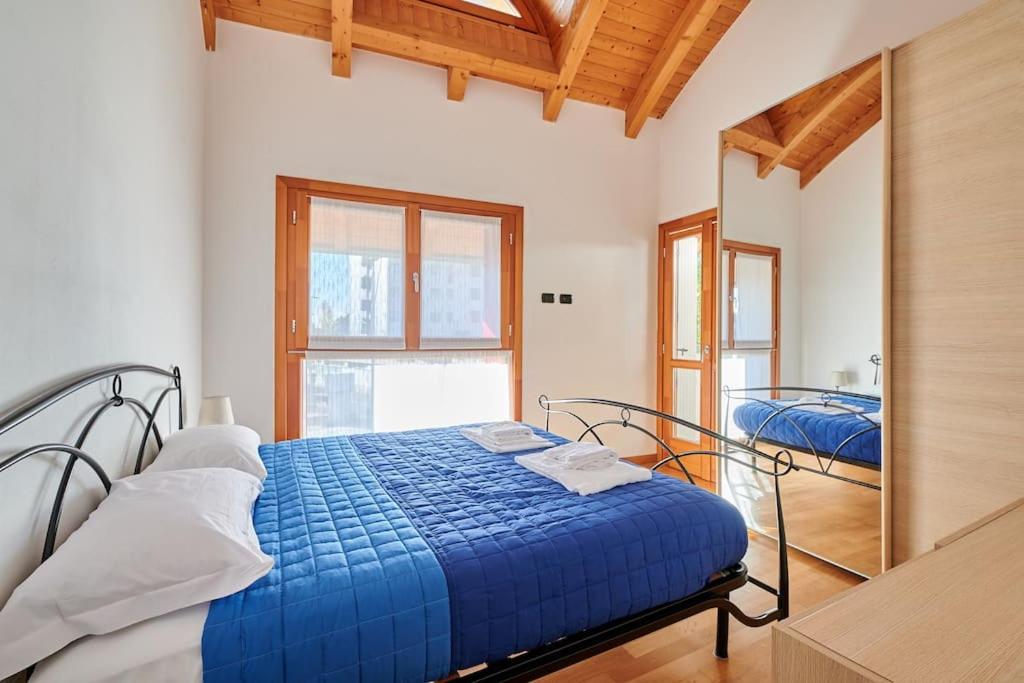 a bedroom with a blue bed and a mirror at [Airport 8 min] A/C - Netflix- Free Parking in Bergamo