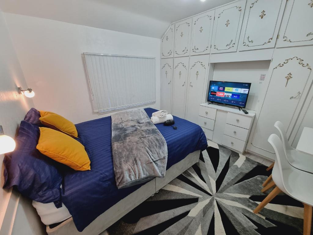 a bedroom with a blue bed and a television at Luxury double bed with Private Bathroom, NETFLIX, work space and WiFi in Leeds
