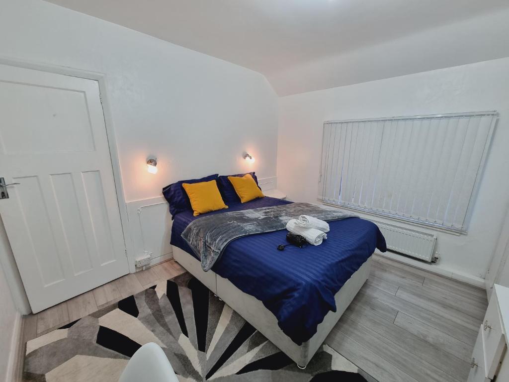 a small bedroom with a bed with blue sheets and yellow pillows at Luxury double bed with Private Bathroom, NETFLIX, work space and WiFi in Leeds