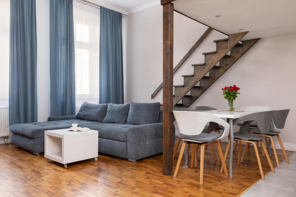 uma sala de estar com um sofá e uma mesa em Fresh Apartments em Cracóvia