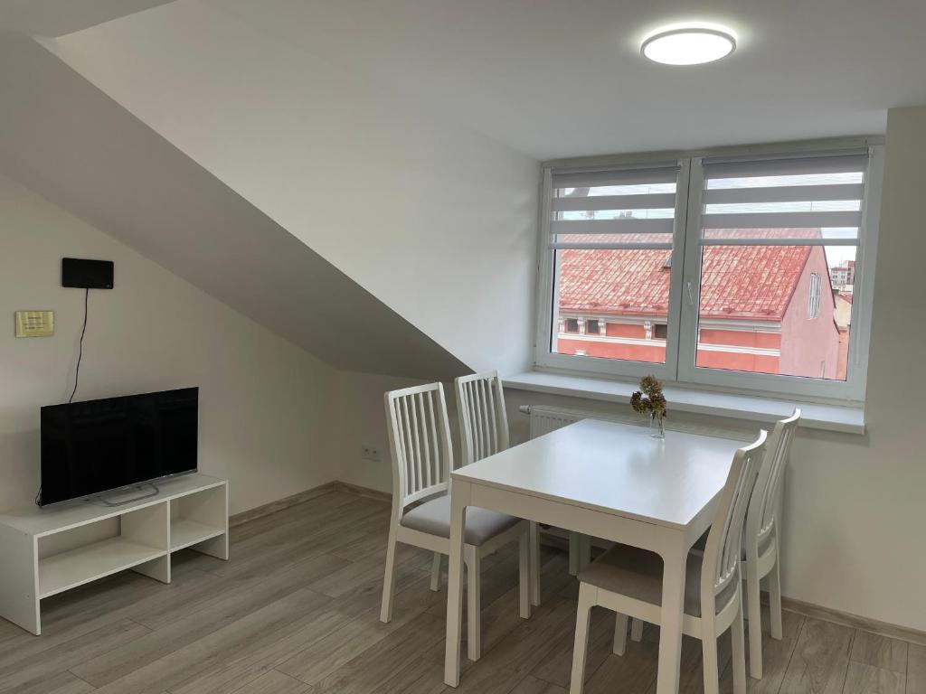 a dining room with a table and chairs and a tv at apartmantt in Cheb