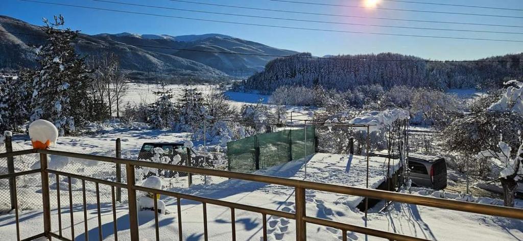 een met sneeuw bedekt balkon met uitzicht op een vallei bij Къща за гости Балканъ in Kyustendil