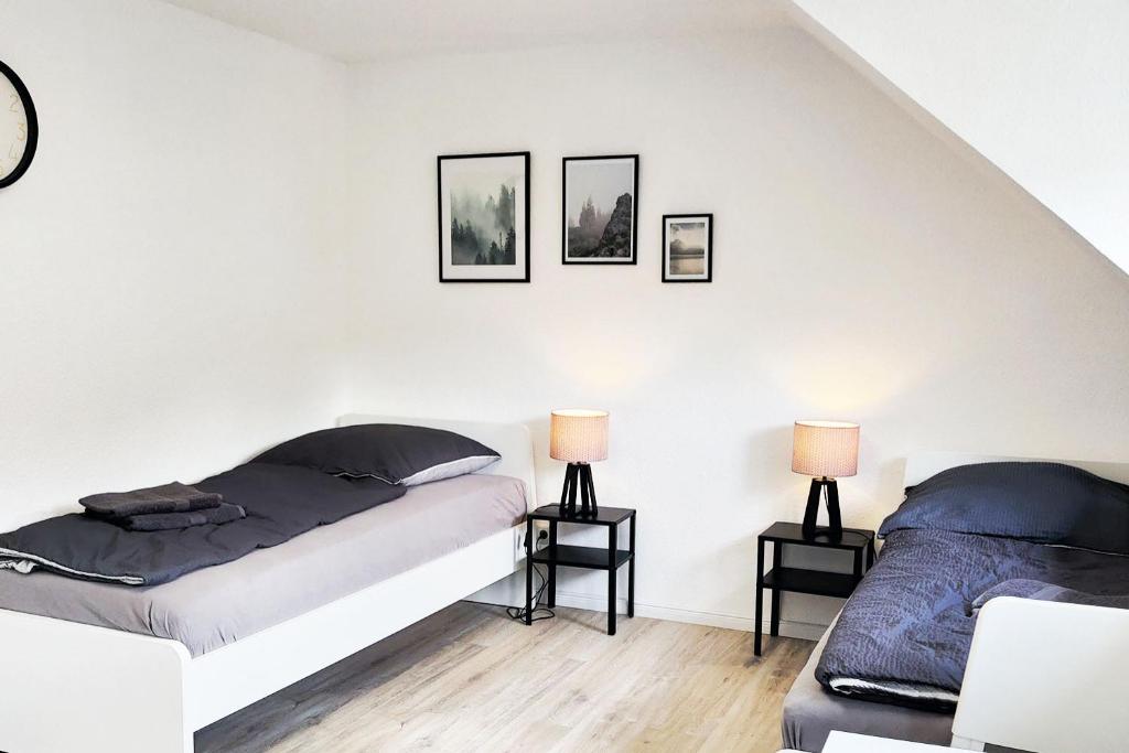 2 camas en una habitación blanca con 2 lámparas en DWK: Monteurhaus bei Neuwied en Niederbreitbach