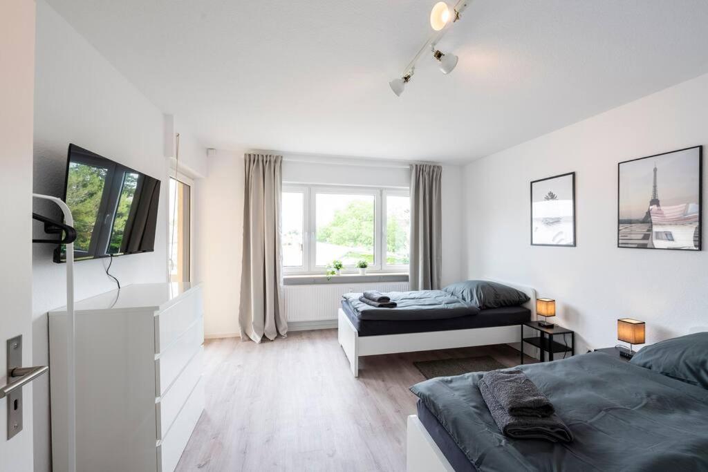 a white bedroom with a bed and a window at HA01 Großes Apartment am Hafen! in Worms