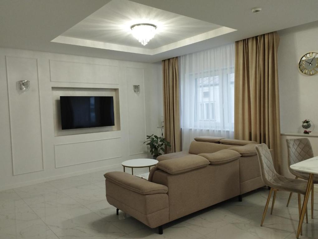 salon z kanapą i telewizorem w obiekcie Apartamenty Centrum w Janowie Lubelskim
