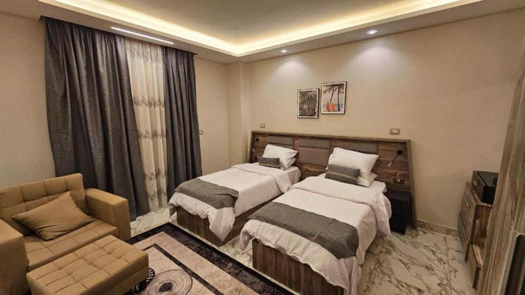 um quarto de hotel com duas camas e um sofá em My Villa em Sheikh Zayed