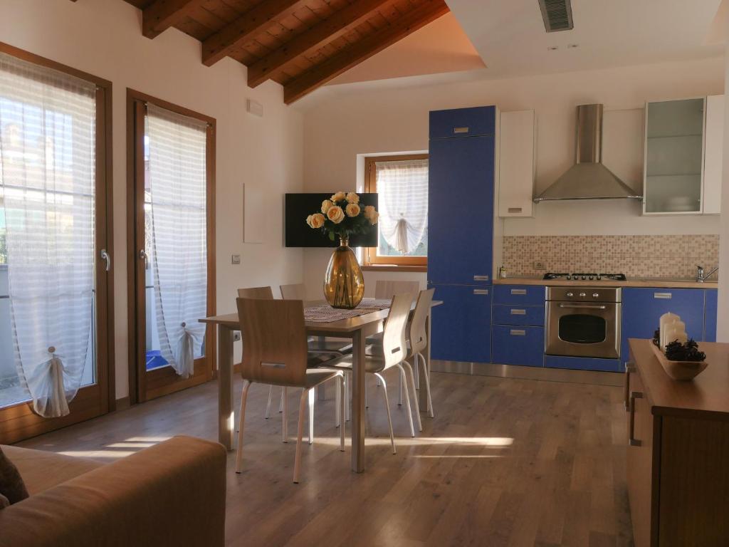 una cucina con armadi blu, tavolo e sedie di The Lake Home a Colico