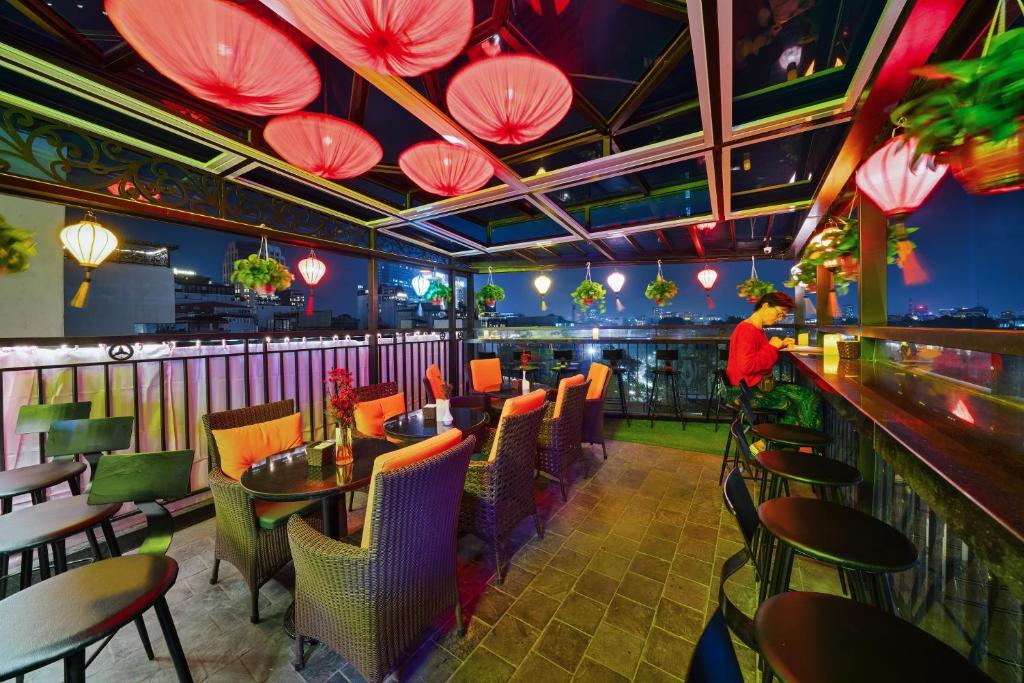 a restaurant with a bar with tables and chairs at Bella Premier Hotel & Rooftop Skybar in Hanoi