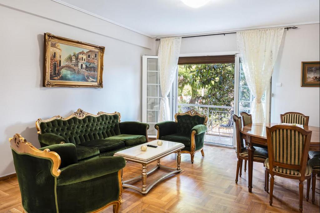 een woonkamer met groene meubels en een tafel bij Danais in Athene