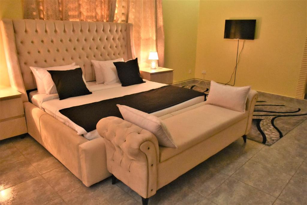 a bedroom with a large bed with a large headboard at Ezeife Guesthouse in Kampala