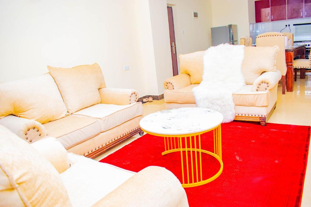 ein Wohnzimmer mit Sofas und einem Tisch auf einem roten Teppich in der Unterkunft Wonderstay in Nairobi