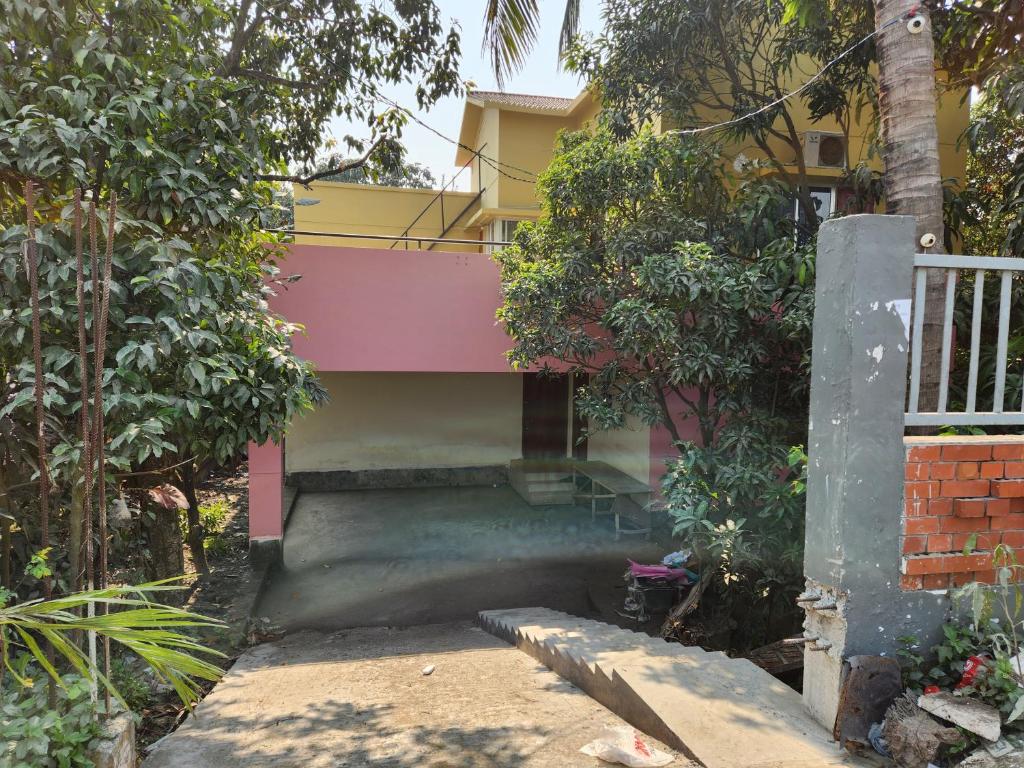 una casa de color amarillo y rosa en Aaira Manjil Guest House, en Dhaka