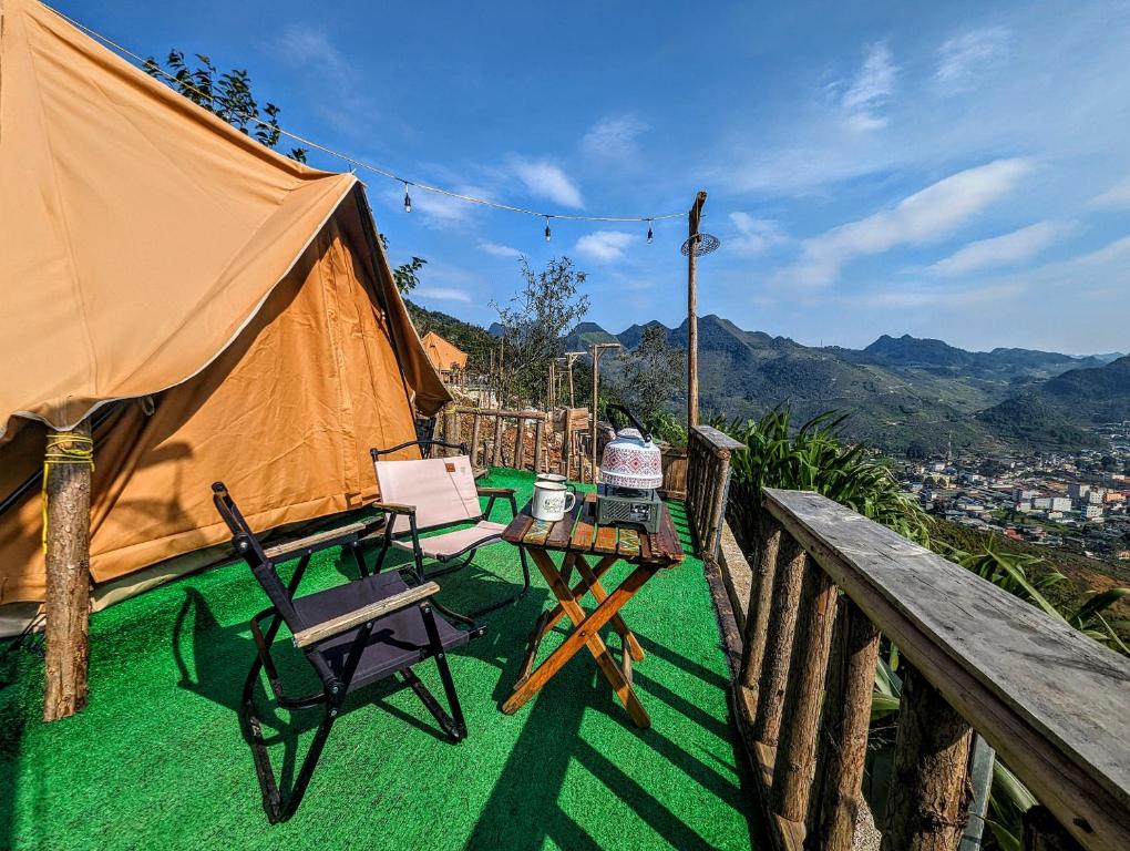 een tent op een terras met een tafel en stoelen bij De Chia Campsite in Mèo Vạc