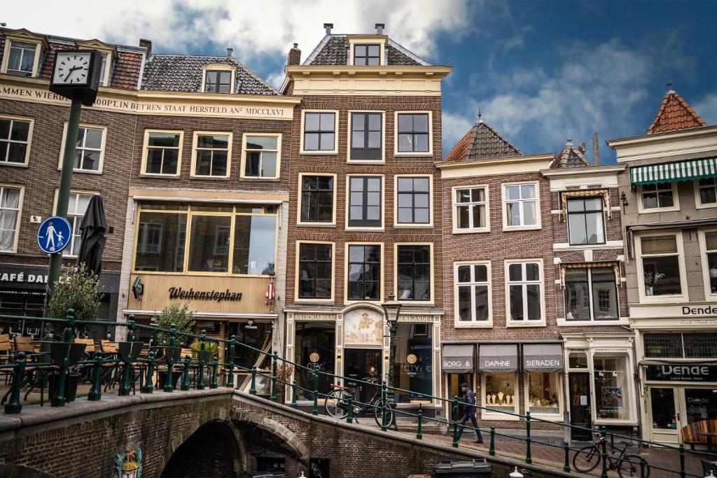 een brug over een kanaal in een stad met gebouwen bij CTY Books in Leiden