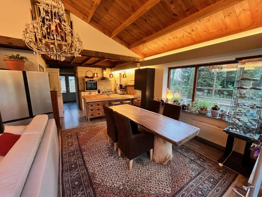 a kitchen and dining room with a wooden table at Vakantiechalet voor 4 plus 2 met sauna in Lanaken