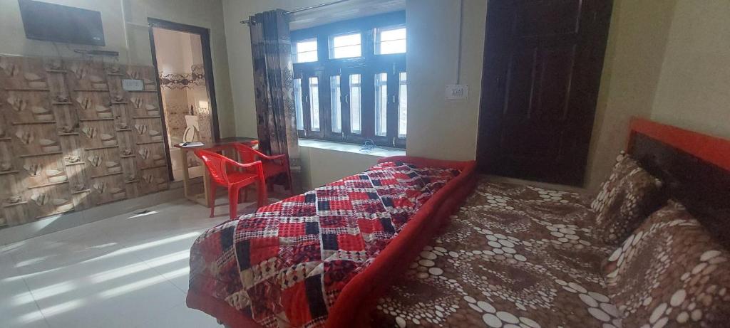 una camera con letto, tavolo e finestra di KRISHNA HOMESTAY a Bhadarwāh