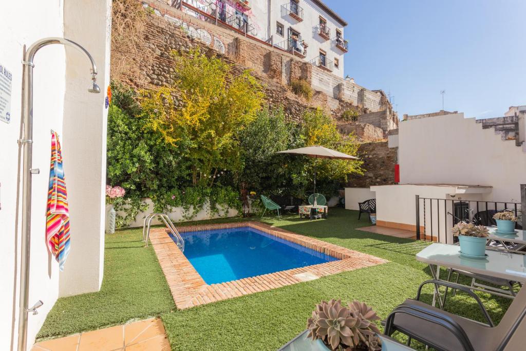 a small swimming pool in the yard of a building at Apartamentos Granata in Granada