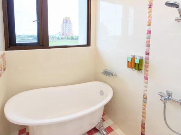 a bathroom with a toilet and a sink and a window at Elegance House in Wujie